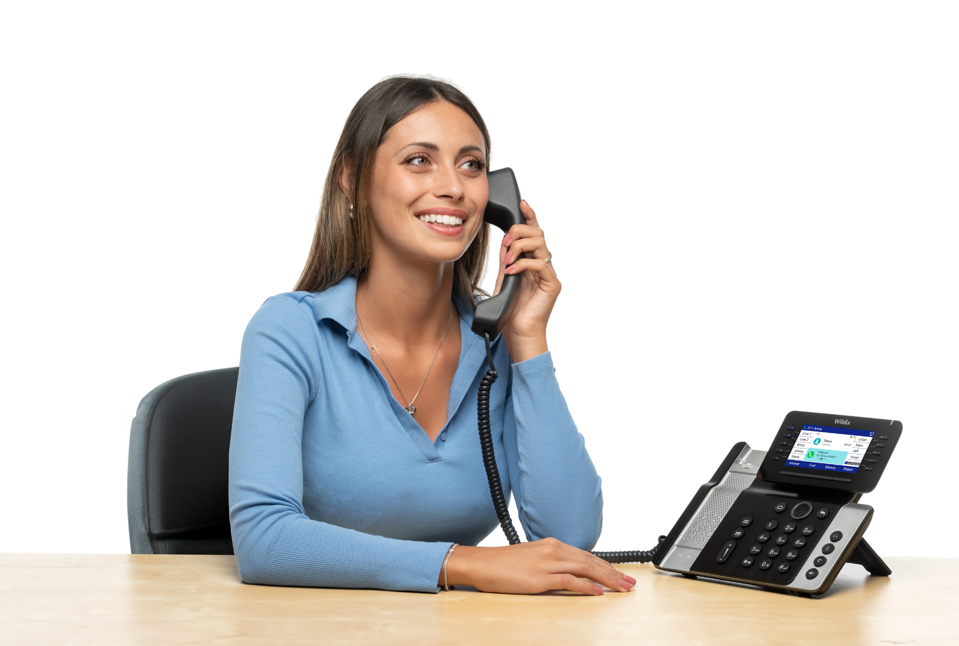 Person on a call at a desk beside a Wildix desk phone