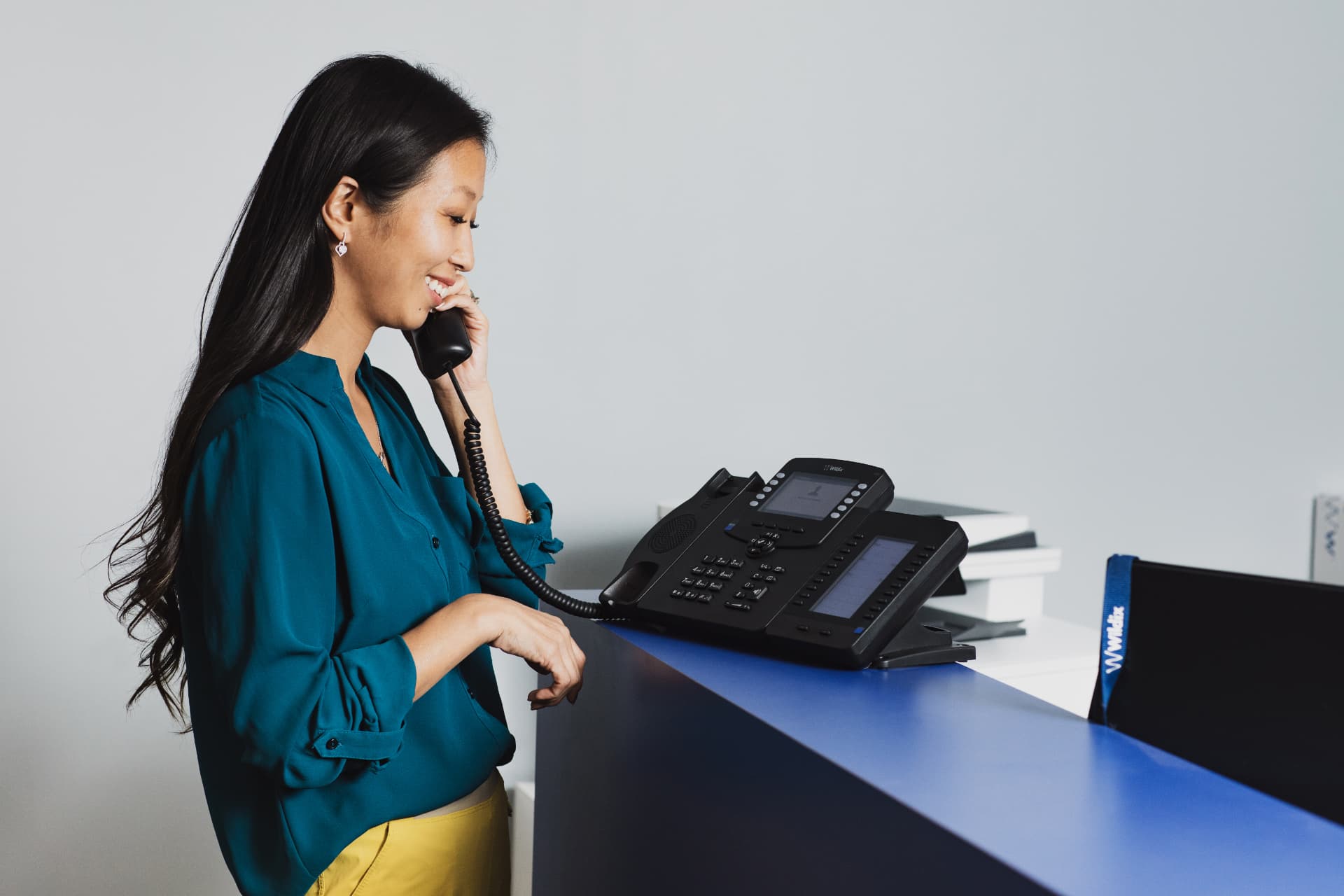 Receptionist answering a call on a Wildix desk phone