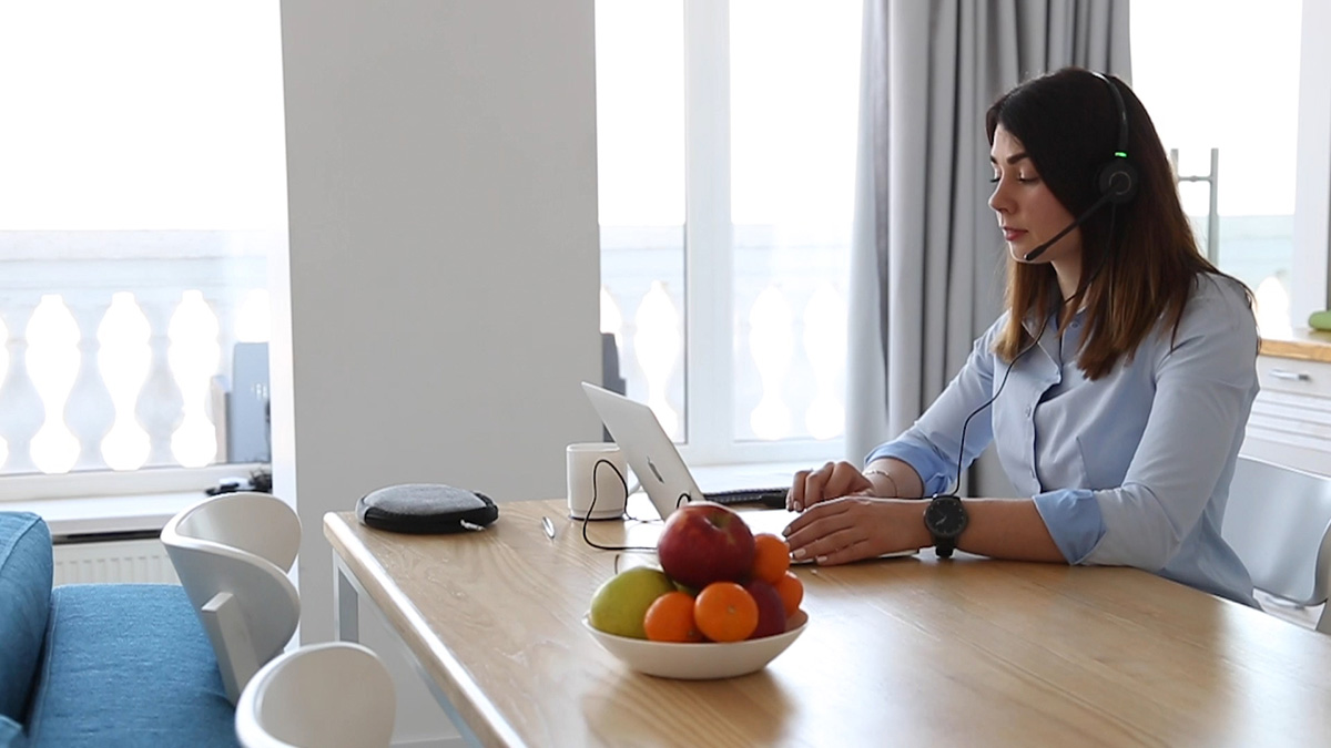 Team member taking a call on a headset while working from home